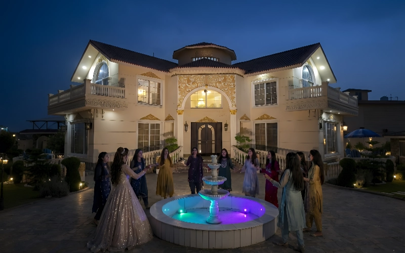 Bride and friends celebrating evening bridal shower at luxury farmhouse with fountain, AH Royal Resort Islamabad