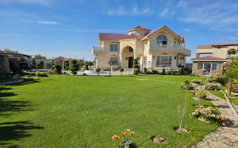 Luxury farmhouse with a spacious green lawn, perfect outdoor location for family photoshoots with natural light and scenic backdrop