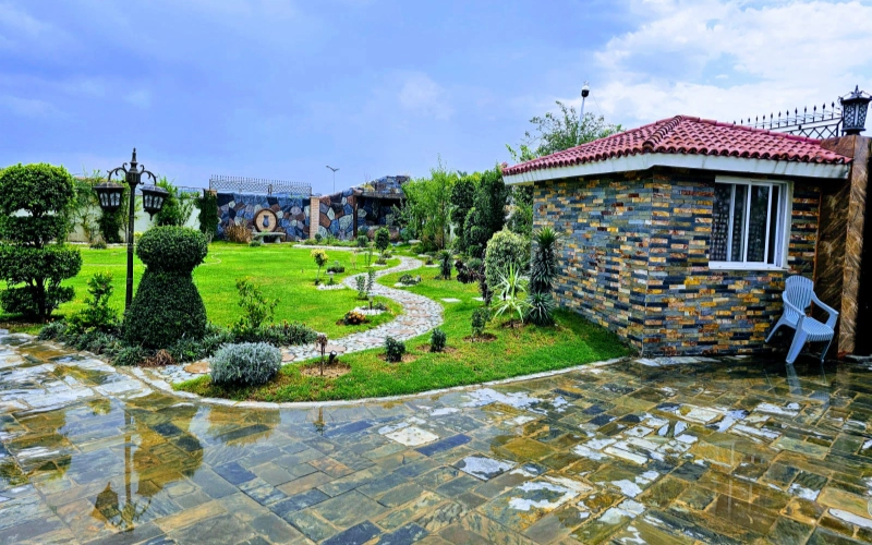 Scenic garden pathway with landscaped greenery and guest house, ideal outdoor location for natural family photoshoots and relaxed poses